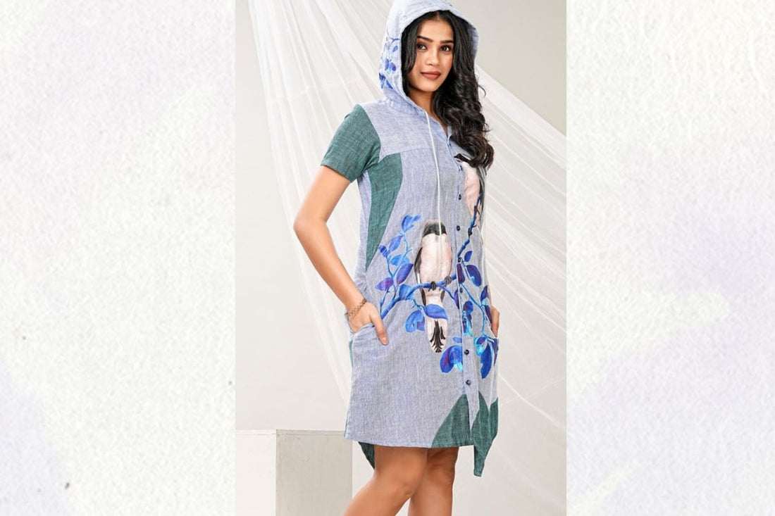 Woman wearing a blue linen hoodie shirt dress with bird print artwork and side pockets by Lataree.