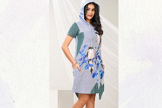 Woman wearing a blue linen hoodie shirt dress with bird print artwork and side pockets by Lataree.